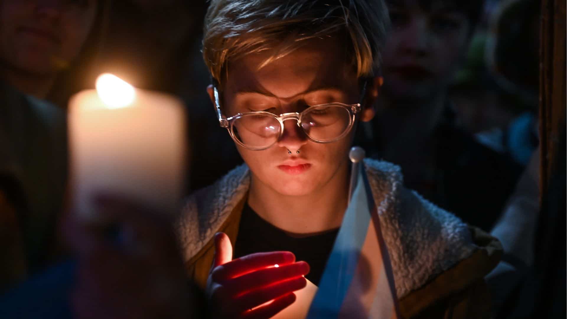 A person hold a candle at a vigil for Transgender Day of Remembrance