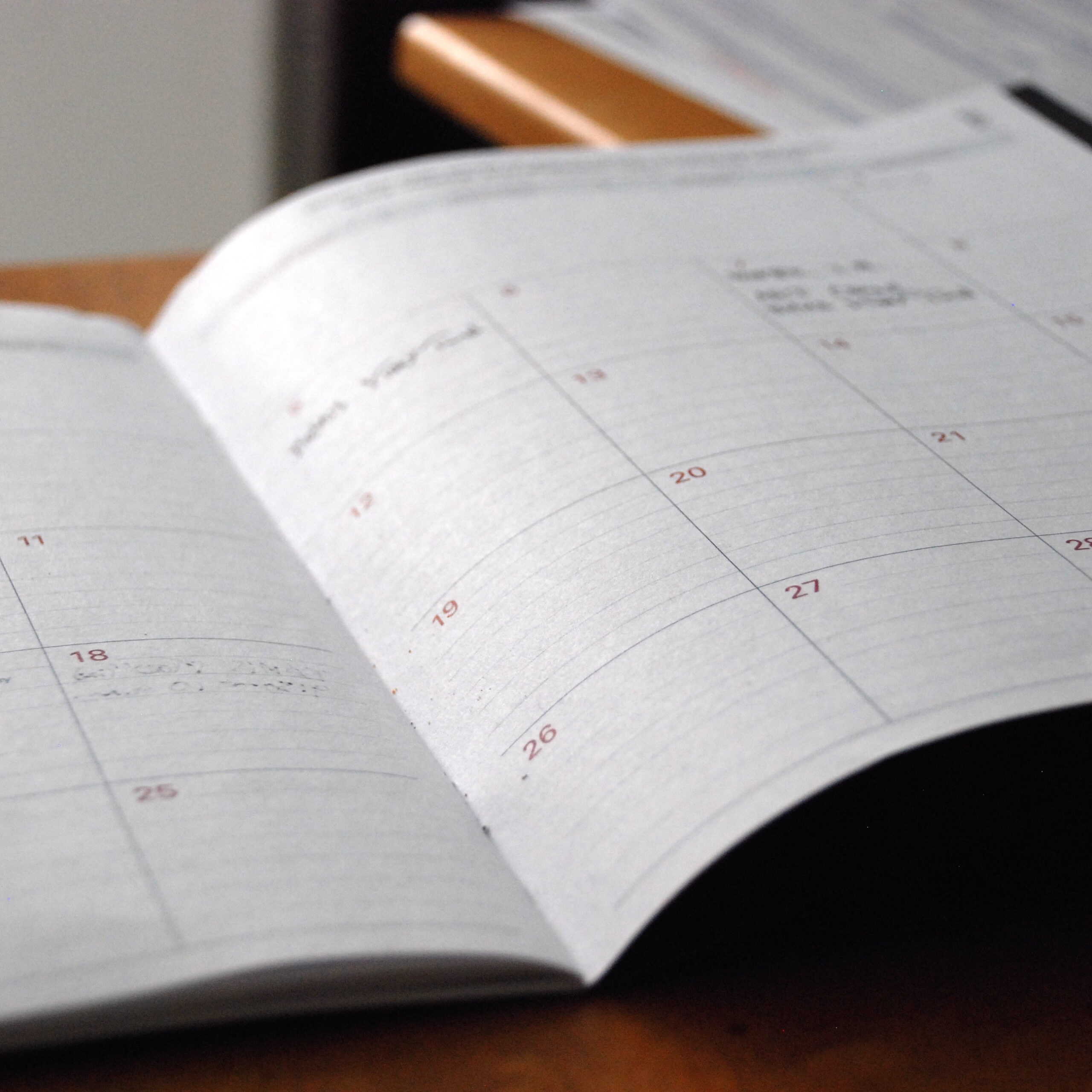 A paper calendar book lies open on a table